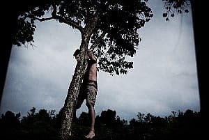 Image shows a man hanging from a tree.