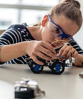 Student putting together a model car - Cambridge Engineering Summer School