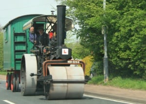 Image shows an old-fashioned steamroller with an 'L' plate on the front. 