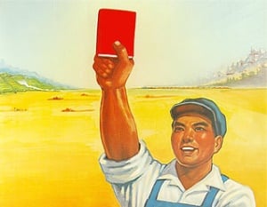 Image shows a farmer holding up a copy of Mao's Little Red Book.