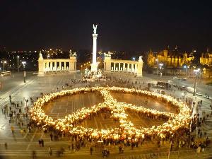 Image shows people in Budapest standing together to form a peace symbol.