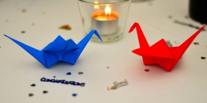 Image shows two origami cranes with sparkly 'congratulations' decorations.