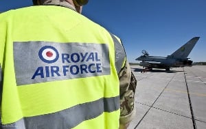 Image shows someone in a high-viz jacket reading "Royal Air Force", standing by a plane.