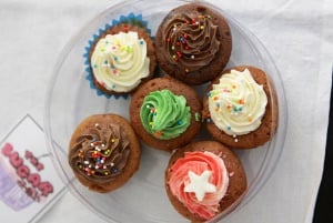 Image shows six homemade cupcakes in a tupperware box. 