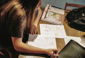 Image shows a girl doing her homework.