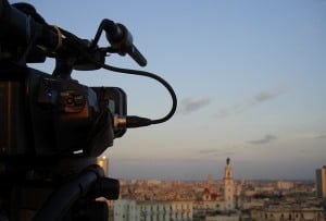 Image shows a film camera pointing over a city.