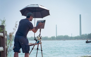 Image shows a painter overlooking a Canadian city.