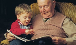 Image shows a grandfather with a small boy on his lap.
