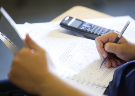 Mathematics Summer School in Cambridge - student writing next to calculator