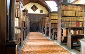 Image shows the wood-panelled old library at Merton College, Oxford. 