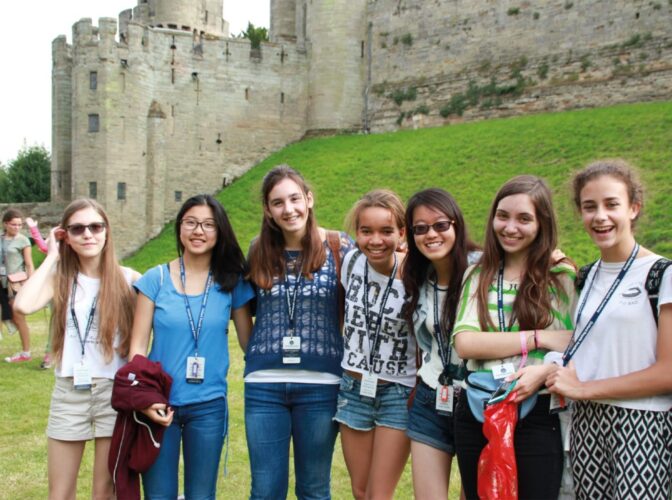 Oxford summer school, go on exciting trips to visit castles and historic landmarks, girls smiling outside of castle ruins.